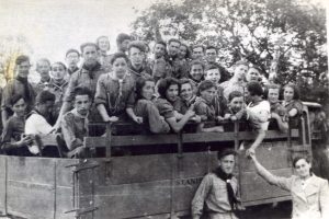יולי 1935, על המשאית בדרך לכינוס גדול של "גורדוניה" בסלוטבינה (כ 30 ק"מ דרומית-מערבית מסטניסלבוב) בו השתתפו מאות נערים ונערות. 
עם משקפים באמצע אהרן שפרלינג ראש הקבוצה, עלה ארצה בלתי-ליגלית ב 1938, היישר למבצע העליה לקרקע הגדול של קבוץ חניתה, שניים שמאלה ממנו הוא שלמה שמרלר ושביעית מימין בשורה הקדמית על המשאית היא זושק'ה זיינפלד, לימים אשתו של שמרלר, בארץ בכפר מע"ש. שלישית מימין בשורה הקדמית, עם בגד לבן, היא שליחה מארץ ישראל שהגיעה במיוחד לכנס ויושב בפינה משמאל הוא גרייף שנהרג במהלך הנסיגה של הצבא הפולני מהעיר בספטמבר 1939. בשורה האמצעית על המשאית, שני מימין הוא זאב האס ושלישי זכריה מלצר. על הקרקע, מוניו הלר.