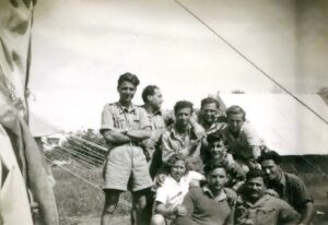 נחלת יצחק, פברואר 1948. בשטח ביה"ס ויצ"ו להכשרה חקלאית וכלכלת בית לבנות, בקצה הצפוני של המושבה סמוך לגדת המוסררה (נחל אילון), שוכן באמצע שנות הארבעים מטה של ארגון "ההגנה".  בתקופת המלחמה עצמה פעל במקום המטה של גדוד 33, הגדוד שמרבית לוחמיו בני הסביבה - נחלת יצחק עצמה, שכונת בורוכוב, רמת גן וגבעתיים. הפעילות בעיקרה כללה התארגנות לסיורים ומארבים באזור אשר האוכלוסיה הערבית בו צפופה ועויינת. עומדים משמאל: ניסים אבדלה, ראובן מנדל, שמואל שמואלי ויענקל'ה לובר ויעקב טרון. חנוך לינצ'בסקי במרכז,  ולמטה, יהודית בן תקוה, אלחנן ענני, אברמיקו רודיטי ויואש רוזמן.