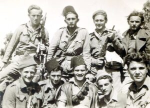 אותו זמן, אותו מקום .... יושבים משמאל לימין: שלום שורץ, אלכס זמברג, יעקב פנחסוביץ', זאב שטרן וניסים אבדלה. עומדים משמאל לימין: יעקב טרון, דוד גראד, יעקב לובר ואלחנן ענני. 
אלחנן אומר לי דברים ישירים ביותר אודות יעקב (יענקל'ה) לובר חברו: הוא מגדיר אותו כ"לוחם ללא חת ומשכמו ומעלה" ויחד עם זאת גם כ"אכזרי באופן קיצוני כלפי האויב". שבועיים בדיוק לאחר שצולמה תמונה זו, לובר נהרג בקרב לכיבוש כפר סבא הערבית.