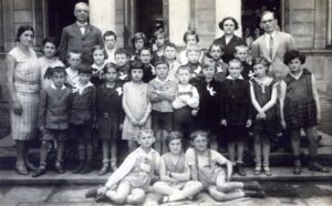 ילדי בית הספר שליד "שפה ברורה", כיתה ב', 1929. המנהל החדש, דוד שאואר, העומד גבוה מאחור בצד שמאל, הוזמן לנהל את בית הספר כשנתיים-שלוש לאחר פתיחתו ועמד בראשו עד פרוץ המלחמה בספטמבר 1939. 
התמונה מעזבון ויטה קסוינר (עומדת בין המנהל למורה יהודית צוייג משמאל). ראו כאמור גם נספח המצולמים והערות לצד התמונה המובילה את התעוד.