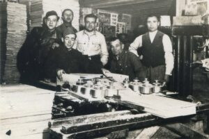 פברואר 1936, בוצ'ו, יושב משמאל, במקום עבודתו במנסרה. אזור נדבורנה, למרגלות הרי הקרפטים, נודע ביערותיו ובתעשיית העץ המפותחת, רובה המכריע בידי יהודים. ראו גם כיתוב על גב התמונה.