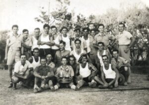 יום ספורט. דב למעלה רביעי משמאל, יצחק אלקיים למטה שני מימין, אחריו עם הגביעים הסרז'נט הבריטי.
