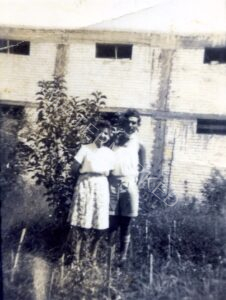 דב וחיה אחותו בחצר ביתם ברמת גן - רחוב מודיעין (כיום בן גוריון) 148, מול הסתעפות רח' חיבת ציון. ברקע מבנה הסיליקט הדו-קומתי שאיכלס במשך עשרות שנים את נגריית שלמה שביל. 
חיה, ילידת 1922, בוגרת מדב בארבע שנים והיא אחותו היחידה.