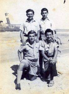 על חוף הים בתל אביב. למעלה מימין: אברהם דנציגר, ג'דה, למטה: בני אטלס, יהושע ויינר. ברקע: אניית המעפילים "פאריטה" שהפליגה מקונסטנצה ועל סיפונה 850 עולים. ב 22 לאוגוסט 1939 הגיעה לחוף תל אביב ובחסות החשכה "העלה" אותה הקברניט על החוף ופרק את "מטענה".