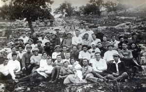 פברואר 1922, קבוצת יצחק לוי שלקחה קודם לכן חלק מרכזי בסלילת כבישי הכנרת, כאן במחנה הסוללים של כביש חיפה-ג'דה. חמש נשים בחבורת חלוצים ססגונית זו. ראש הקבוצה יצחק לוי בקדמת התמונה במרכז (שתי בנות לפניו). ככל הנראה תצלום חגיגי לרגל סיום העבודות.