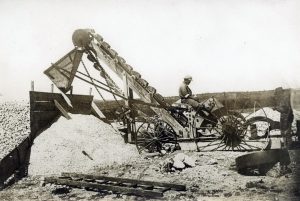 האבנים אשר רוסקו קודם לכן ידנית, מועברות לגריסה במכונה זו. החצץ המתקבל משמש מצע לסלילת הכביש. שני הצילומים של הצלם החיפאי הנודע צבי פייגין (1884-1962).