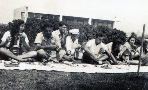 1940, חוגגים, ברקע בית התרבות של הקבוץ.
משמאל: נחמה פריבר, המורה יוסף ניישולר, נתן יונתן, המורה אלכסנדר שחורי, יוחנן זריז, רנה פרידמן, רנה צביאלי. המבנה, בקומפלקס חדר האוכל של הקיבוץ פרי תכנונו של האדריכל אריה שרון. בנייתו החלה ב 1936 ונמשכה 3 שנים, כיום עומד בשיממונו בתחומה של פתח תקוה.