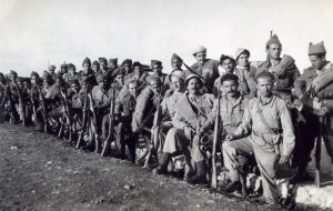 כיתוב: כפר הס, 21.4.1948
כח שיצא ממחנה 20 לפעולה של פיצוץ בנין ליד כפר הס. למטה מימין: חיים מילר מפקד הכח, אריה שניטמן, דוד וייסויסר, ר. ספירשטין, שמוליק בוגין, הולצמן (רץ פל'), ?, נפתלי ארליך, נפל בקולה כאשר הג'יפ בו פונה כפצוע ! חטף פגיעת פגז ישירה. למעלה: 4 ישראל לויצקי, 5 מוטולה.