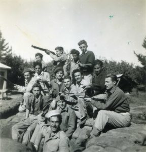 "שווייקה 28.1.1948" - חברה מבנימינה וחדרה
על שקי החול של עמדות השמירה ליד בית האריזה. החברה שאך גויסו, הוצבו לפעילות בטחון שוטף במקום. מיכאל לדני בחזית, יואב וילדר מימין, לא מזוהה אחריו, עמיצור כהן, אברהם אהרונוב (עם כומתה), ברוך איקרי (סיגריה בפה), יויינה מתחתיו. הבחור למעלה אוחז רובה אנגלי.