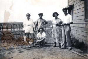 יושבת רחל תבור לבית גוז, נולדה בדובנה ב 1911, עלתה ארצה ב 1935 לאחר הכשרה בצ'נסטוכוב, נפטרה ב 2008. עומד מימין, בעלה משה תבישור (תבור). תלמיד הגמנסיה "תרבות" ברובנה, משה נטש את הלימודים כדי לצאת להכשרה בצ'נסטוכוב, שם גם הכיר את רחל, עלה ארצה ב 1933 ונפטר ב 1997. לצידו בשמלה פרחונית לא זוהתה בשמה. מישקה קפלן במרכז ולצידו, בלבן משמאל, אהבתו הגדולה שבאה אל קיצה בנסיבות שלא הובררו כל צרכן. רחל גוברמן, חברתו לקבוצת תשעת העולים הראשונים מצ'נסטוכוב, כתבה בהספד לאחר מותו בטרם-עת, כי מישקה עזב את הקבוצה "מסיבות משפחתיות" ולא יספה. ומכל מקום, ב 20 בנובמבר 1936 תועד רישום חתונתם של מישקה ואחת חיה שרה לבית הילר ברבנות רמת גן. לקבוצה הוא לא חזר כאמור. עזיבה בכלל ובחירה בדרך חיים חדשה, וקפלן לא היה מקרה יחיד, היתה תמיד נושא רגיש ב"שומר הצעיר" והתקבלה בחוסר שביעות-רצון בולט.