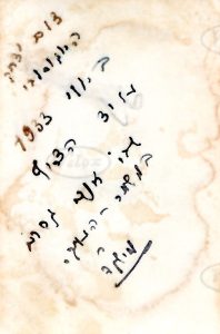 על גב התמונה שירבט מישקה: "צום יצחק היוגוסלבי. ביולי 1933, על יד הצריף שבו אנכי גרתי במשמר העמק. מישקה". 
יצחק היוגוסלבי הוא יצחק שלזינגר, חבר גרעין השוה"צ מיוגוסלביה אשר עלה ארצה ב 1932 ושהה בין היתר במשמר העמק. בהמשך דרכו חנה הגרעין במגדיאל ומאוחר יותר על אדמות חרתיה (קבוץ שער העמקים).