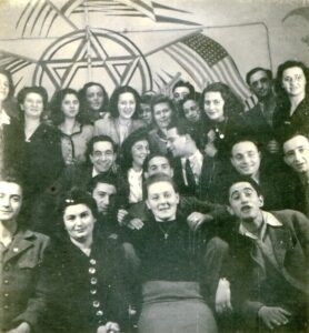 במשרדי ארגון הסעד היהודי-אמריקאי, ה"ג'וינט". 
ארגון הסעד בעל העוצמה הגדולה ובווינה היה לב פעילותו לאירופה כולה. שיתוף הפעולה עם ה"ג'וינט" היה קריטי להצלחת פעולות "הבריחה", העברת כספי הסיוע שלו ביניהם. נציגת הארגון בחזית במרכז, אסתר ושלמה פאר למעלה מימין, גרטה זנדברג למעלה שניה משמאל, אייזיק כץ בשורת הביניים ראשון מימין, בולק זנדברג שני.