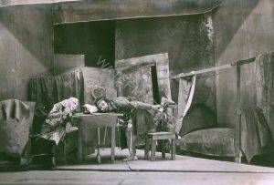 מתוך "נשפי י.ל. פרץ" - ההצגה הראשונה של התיאטרון ! הצגת הבכורה התקיימה באולמה של גמנסיה "הרצליה" ברח' אחד העם בתל אביב במוצאי חג השבועות, 19 במאי 1926 (גרסה אחרת אומרת שבמוצאי שבת, ה 22 במאי). ההצגה היתה בנויה מספר מערכונים וכאן "כעסה של אשה" עם דבורה קסטלנץ וחיים אמיתי. 
הצילום מעשה ידי משה קפלנסקי (1887-1968), מי שתעד במצלמתו רבות מהצגות ה"אהל" (כמו גם "הבימה", "המטאטא" ועוד), הקים את הסטודיו הנודע שלו "פוטו פלסטיקה" ברח' אלנבי 50.