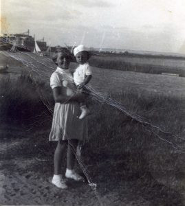 1937, חיה שחורי ורן בן דודה על שפת הירקון.
למעלה בשמאל התמונה ניתן לראות סירות מפרש וכן את הנגריה הגדולה לבניית ושיפוץ סירות של סניטובסקי. מעברו השני של הירקון שכן הכפר הערבי ג'מוסין.