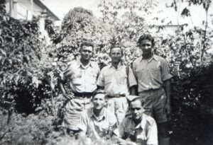 1944-45, בחצר בית משפחת טריוואקס בבני ברק. הבית היה ממוקם בתוך פרדס גדול (נודע כ"פרדס טריוואקס") ובשטחו, הרחק מעיני הבריטים, התקיימו דרך קבע אימונים של "ההגנה". 
עומדים: מימין רפאל ("פוליק") שקלרש, במרכז מישאל שחם, מפקד בכיר ב"הגנה", נודע כמפקד הפעולה (מעוררת המחלוקת) לפיצוץ מלון "סמירמיס" בירושלים, ומשמאל, הנוטר גבריאל טריוואקס. כורעים: מימין בנימין טריוואקס, אחיו הצעיר של גבריאל, במדי הצבא הבריטי, ומשמאל, הנוטר צבי אברמסון. הפעילות המחתרתית, מיותר לציין, נעשתה במקביל לשרותם של הלוחמים הללו במסגרות הצבא או השיטור הבריטים ! ומפורסם מטבע הלשון שטבע בן גוריון באותו הקשר: "עלינו לעזור לאנגלים במלחמה כאילו לא היה ספר לבן, ועלינו לעמוד נגד הספר הלבן כאילו לא הייתה מלחמה".