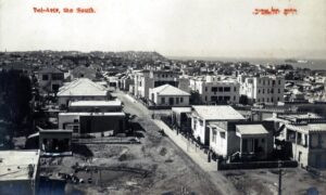 אמצע שנות העשרים (של המאה ה 20). כחצי מאה אחרי שפליקס בונפיס צילם את הפנורמה שלו וכשלושים שנה לאחר תצלום הבזאר המרהיב (שני הכותרים הקודמים), כאן באזור שמצפון ליפו, הפרדסים והבוסתנים נעלמו, והוא בנוי עתה בצפיפות מירבית, עדיין בניה נמוכה וצנועה יש לומר. ניתן לזהות כאן את שכונותיה הדרומיות של תל אביב - נווה צדק ונווה שלום ואת שכונות אירשיד ומנשיה היפואית המהוות כולן גוש רצוף אחד. מחנה האוהלים בין הבתים בימין התמונה הוא שכונת "אהל משה", השכונה שהוקמה ב 1906 ואשר היתה למעשה השכונה היהודית האחרונה בתחומיה של יפו (טרם הקמתה של אחוזת בית/תל אביב ב 1909), כיום סביב רחוב הראשונים שבין שבזי ולילנבלום. גלויה מסוג Real Photo, הוצאה לא מזוהה.