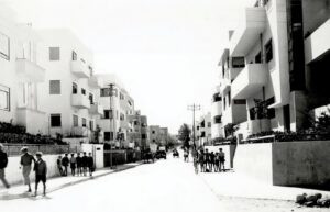 "מעונות עובדים" בתכנון האדריכל אריה שרון, מסמליה המובהקים של תל אביב, מבט ממזרח למערב לאורך רחוב פרישמן (פינת פרוג), אמצע שנות השלושים.