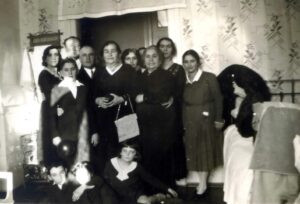 1931 בבית המשפחה, ארוע לרגל בר המצווה של משה שטריק. 
עומדים מימין: פרידה פיסיוק, רחל, אמו של משה, מעט מאחור, שלישית, אפשר שסבתו של משה מצד אביו, רביעית, צעירה לא מזוהה שרק ראשה ניבט מאחור, חמישית, במרכז, תיק בידה, שלומית פיסיוק, סבתו של משה מצד אמו, שישי, אלכסנדר שטריק, אביו של משה, שמיני, מעט מאחור, לא מזוהה, תשיעי, חתן השמחה משה שטריק, וקיצונית משמאל, רחל, אשת לייב פיסיוק, אחות אלכסנדר שטריק (שמה ושם משפחתה זהים לאלה של גיסתה). על הרצפה, ארתור ויהודית , אחיו ואחותו הצעירים של משה.
