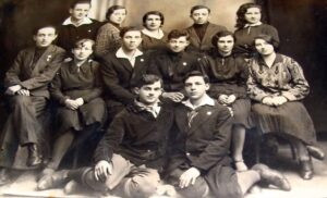 מדריכים ומדריכות בהנהגת קן "השומר הצעיר", אותה תקופה והרכב אנושי דומה לזה שבתמונה הקודמת. 
זוהו בוודאות בשמם: בשורה העליונה משמאל חיים קופרשטיין, יליד 1911, בוגר גמנסיה "תרבות", עלה ארצה ב 1933, קבע את מושבו בתל אביב ולאחר מכן בחיפה. במרכז פנינה (פרלה) אירלין, ילידת 1911, עלתה ארצה ב 1934 וכאן בקבוץ עין השופט, קרן לאחר נישואיה. בשורת הביניים, ראשון משמאל פנחס (פינק) רסיס, יליד 1911, פליט בברה"מ בזמן מלחמת העולם, הגיע ארצה ב 1948 וקבע את מושבו בתל אביב. שלישי משמאל זיסקינד שטיין, יליד 1913, בוגר גמנסיה "תרבות", עלה ארצה ב 1934, כאן זיסקינד כרמל, אף הוא בעין השופט. בחזית משמאל יהושע (שיקה) בורינטר, יליד 1911, נספה בשואה.